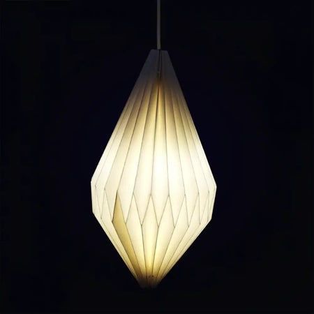 A warm cream-colored paper pendant light with a geometric faceted design in a white origami pendant shape