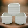 White porcelain tealight holder 6cm x 6cm with a banded square design and horizontal ridged texture