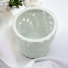 White porcelain tealight holder with cylindrical shape and embossed fern leaf pattern made of ceramic