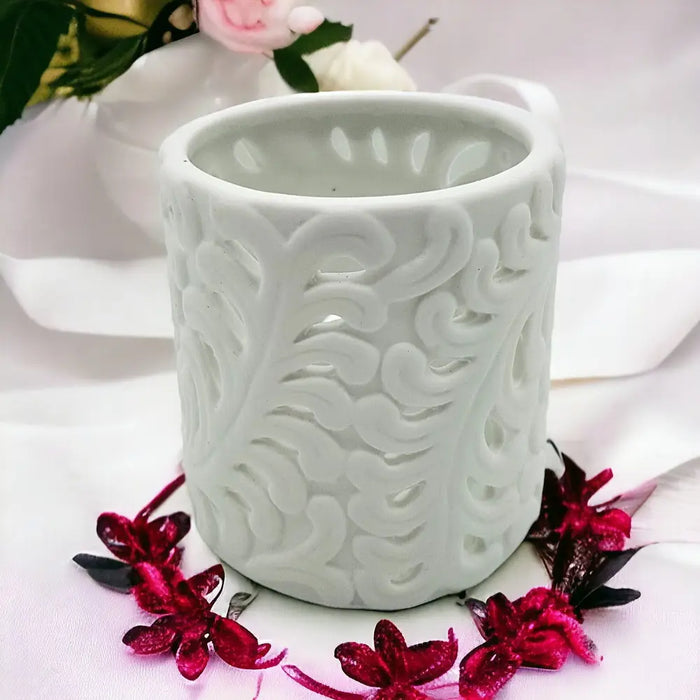 White porcelain tealight holder with intricate fern design and swirling cut-out patterns made of ceramic porcelain tealight holder