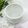 White porcelain tealight holder with a textured embossed pattern and small raised dots inside ceramic planter style