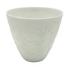 A white porcelain tealight holder with a subtle embossed floral frangipane design in a simple ceramic cup shape
