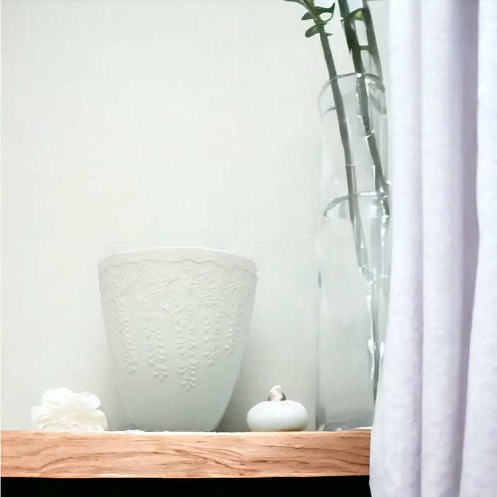 White porcelain tealight holder with a delicate embossed wisteria floral pattern in a white ceramic vase style