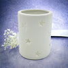 White porcelain tealight holder with star design cutouts available in two sizes for candle use