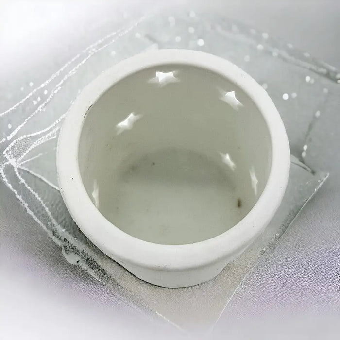 White porcelain tealight holder with star design cutouts inside available in two sizes