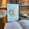 White wellness journal with a textured cover, rose gold tree of life design, moon phases, and wellness journey focus