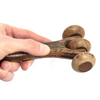 A dark brown wooden massage tool with three rounded polished spheres on a smooth handle three disc roller