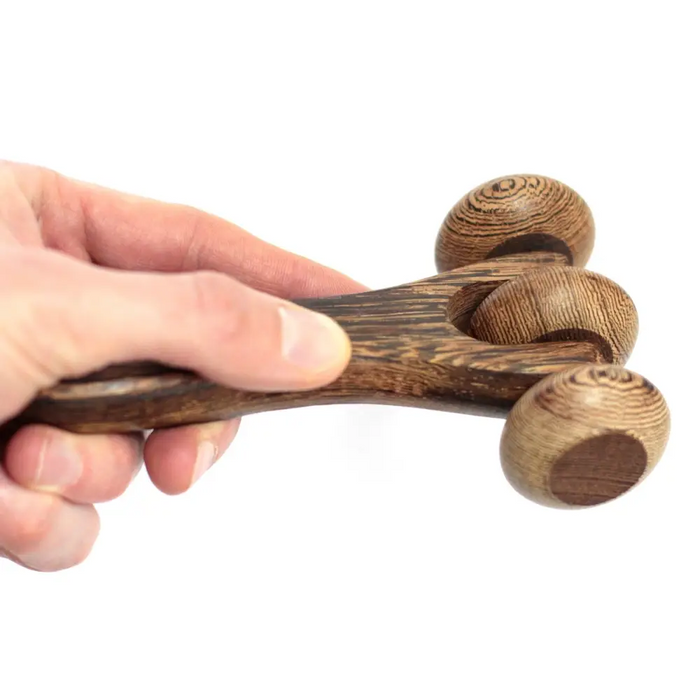 A dark brown wooden massage tool with three rounded polished spheres on a smooth handle three disc roller