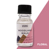 A clear glass 10ml woodland walk fragrance oil bottle with black cap and floral allergen declarations label