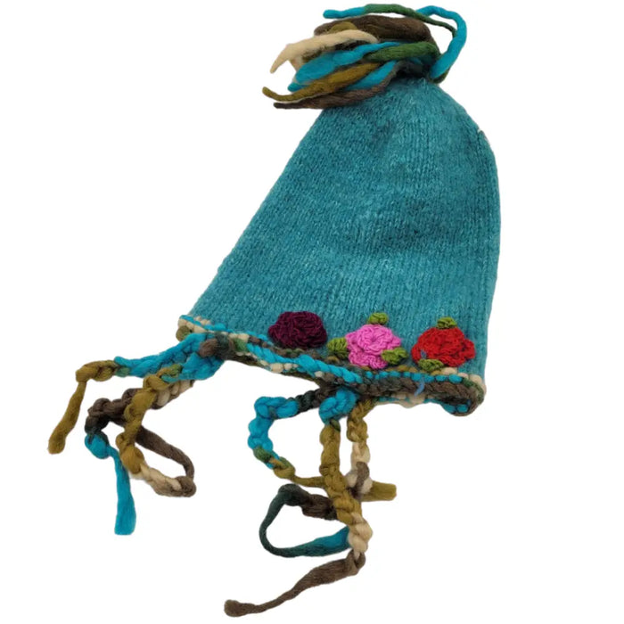 A hand-knitted teal wool hat with colorful embroidered flowers and braided tassels for adults