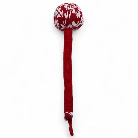 Red fabric-covered wooden wormwood massage hammer with white floral pattern on the head for wormwood massage