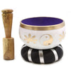 White tibetan singing bowl set with gold yin yang symbol, floral designs, purple interior, and brass rim