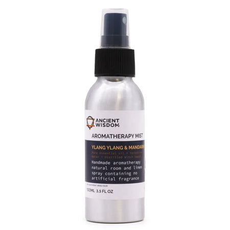 A sleek silver spray bottle with black nozzle labeled ancient wisdom aromatherapy mist ylang ylang essential and mandarin essential oil