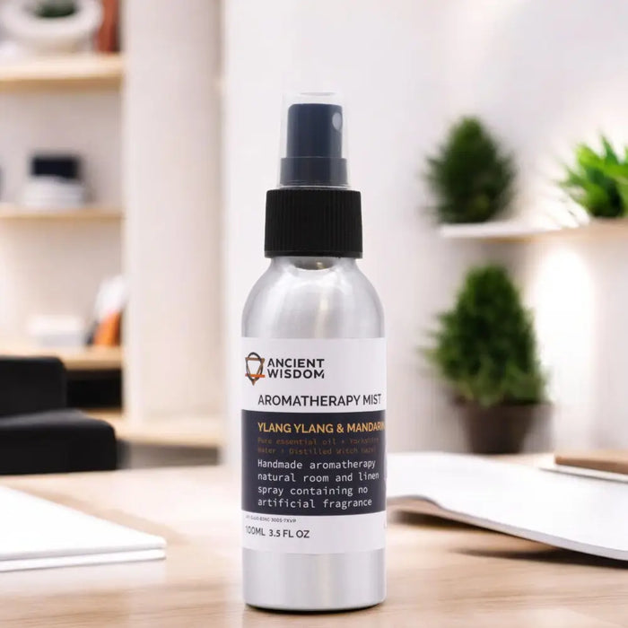 Silver spray bottle with black pump labeled ancient wisdom aromatherapy mist ylang ylang mandarin essential oil with witch hazel